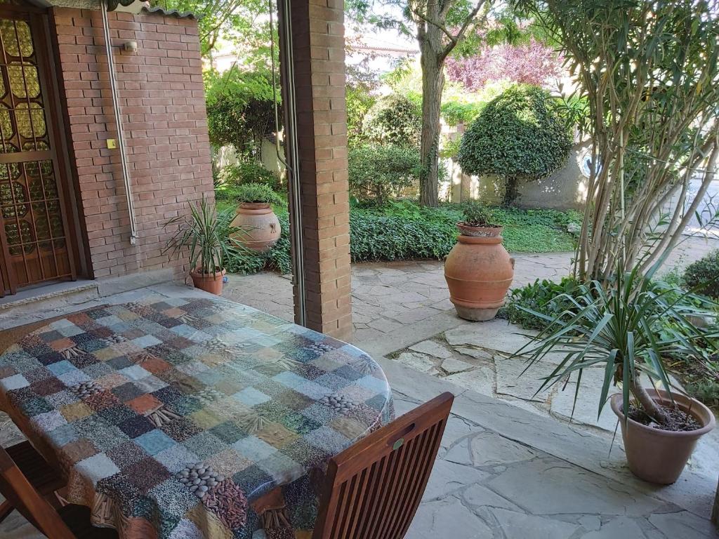 un patio con mesa, sillas y macetas en B&b rustic chic Casa Salva, en Molinella