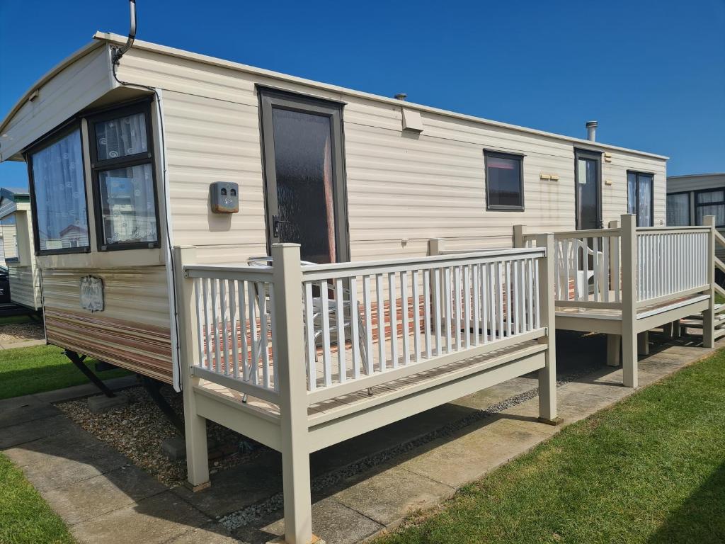a mobile home with a porch and a deck at 6 Berth Panel heated on Sealands Baysdale in Ingoldmells