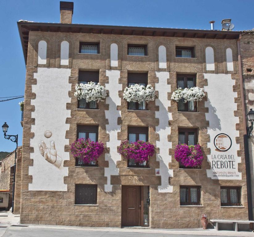 a building with flower boxes on the side of it at La casa del rebote in Acedo