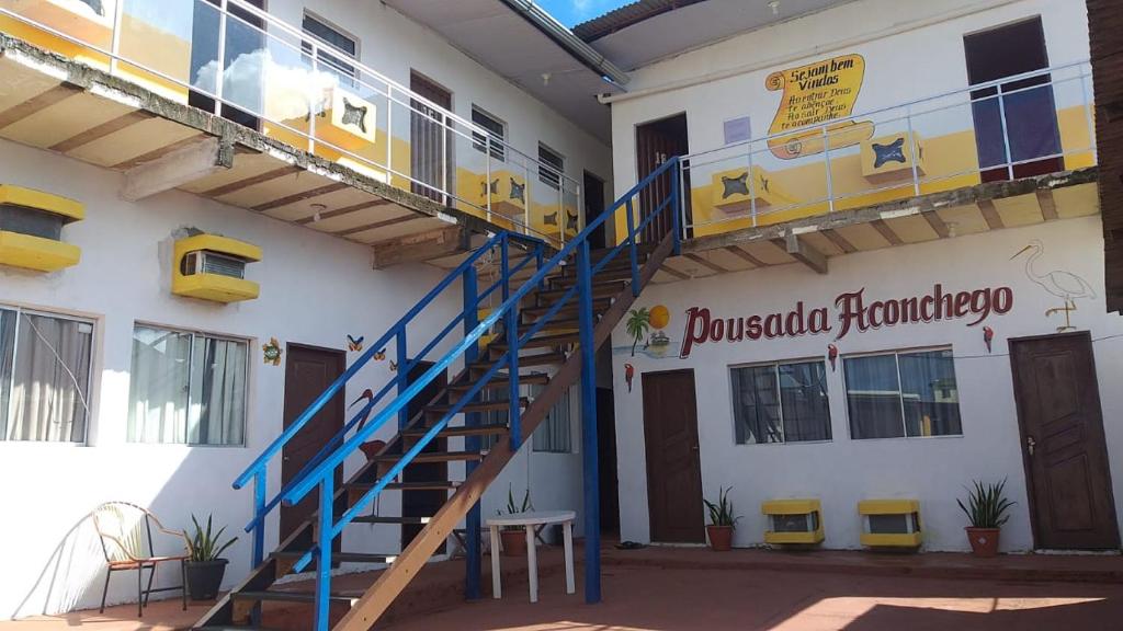 a building with a blue staircase on the side of it at Pousada Aconchego in Salinópolis