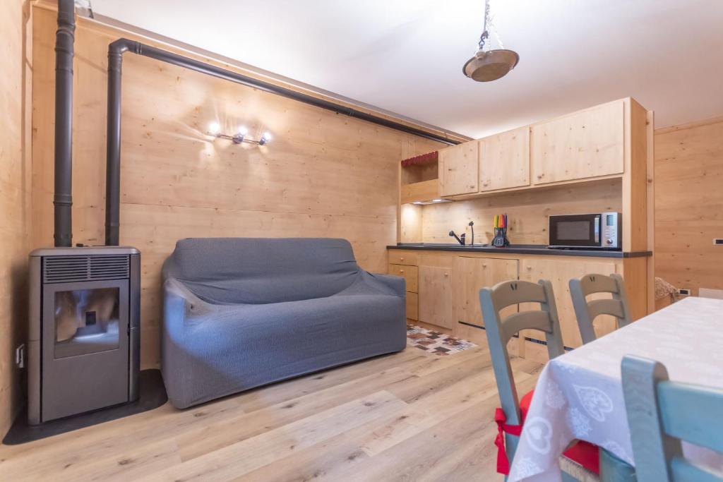 een woonkamer met een bank en een tafel en een keuken bij Cesa Palue in Rocca Pietore