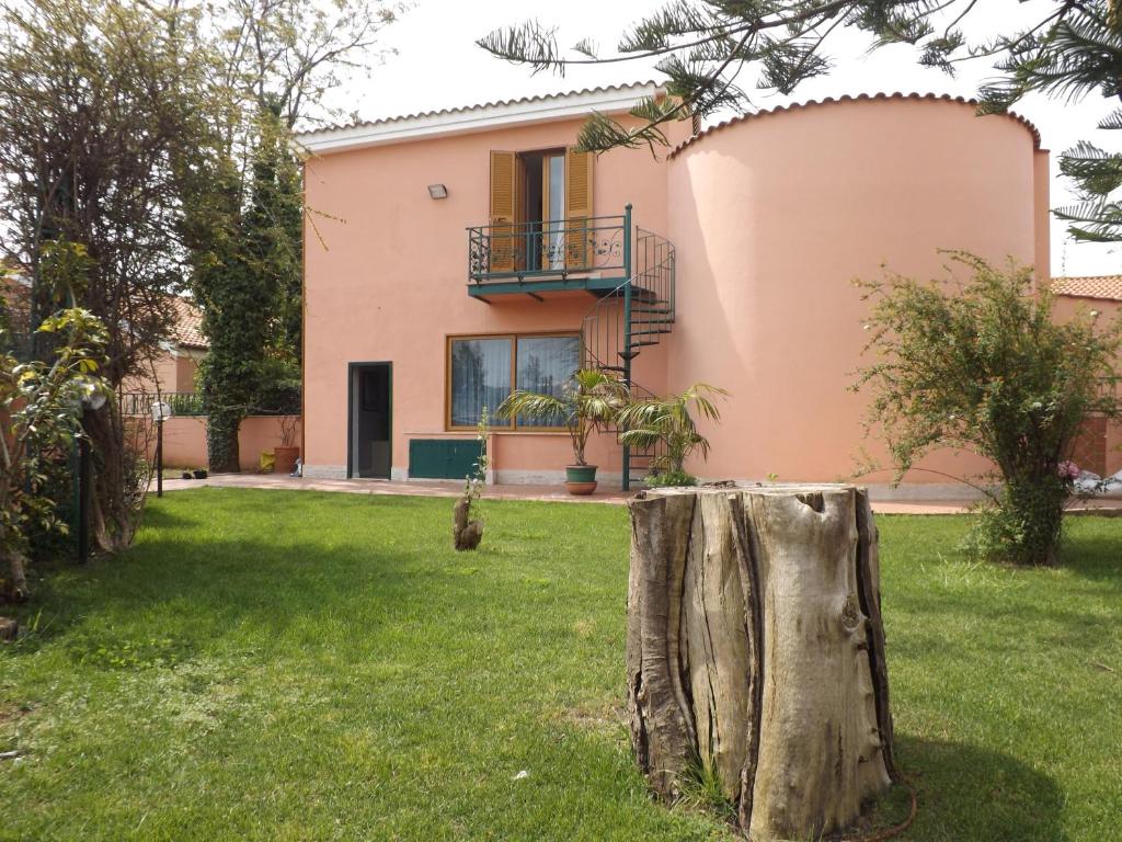 una casa con un tronco de árbol en el patio en La Perla Del Tirreno, en Santa Severa