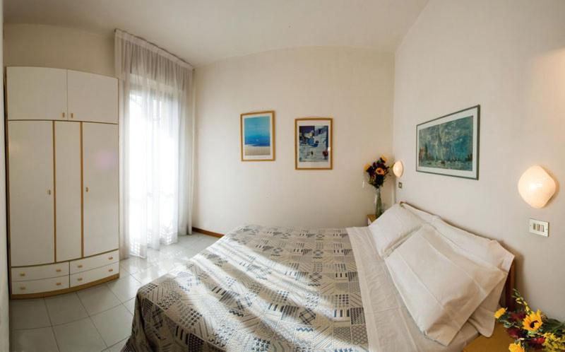 um quarto com uma cama grande e uma janela em Residence Caterina em Cattolica