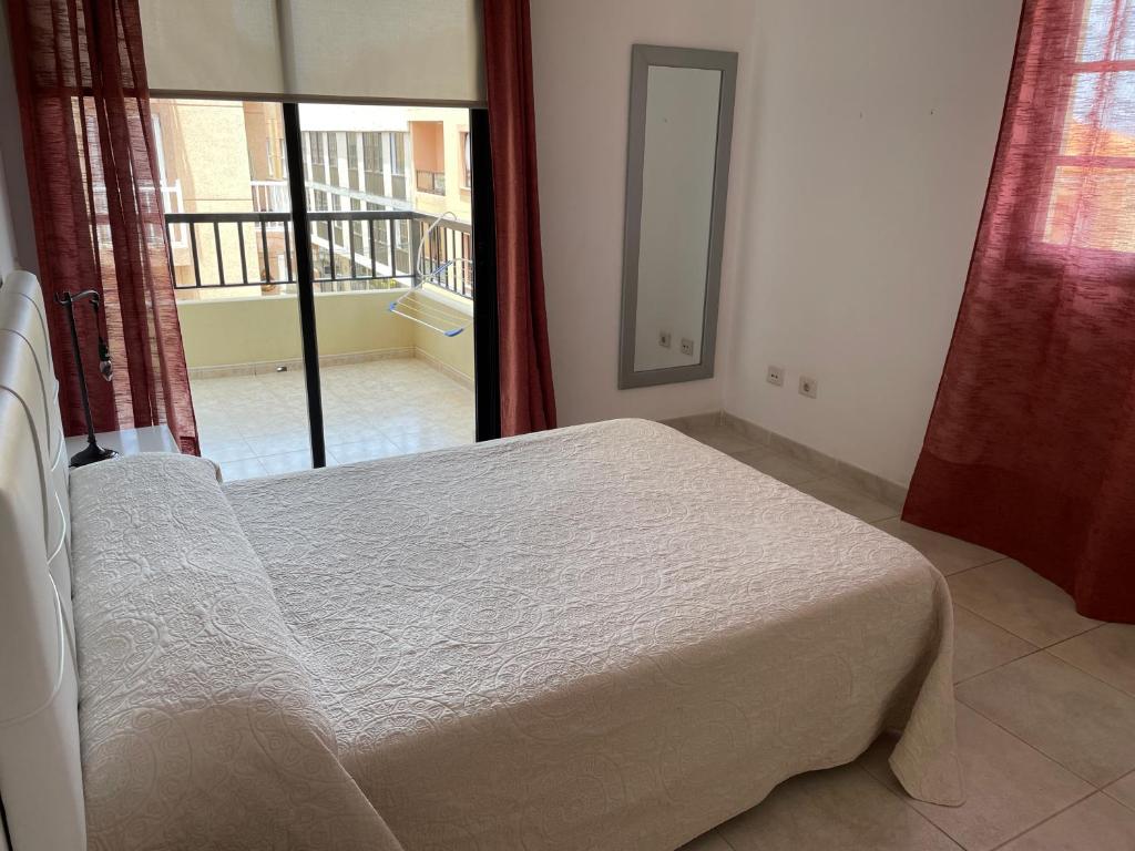 une chambre avec un lit et une vue sur un balcon dans l'établissement Calle Eusebio Carballo Estévez, à Corralejo