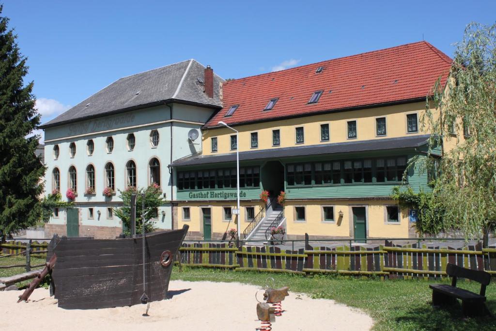 a large white building with a red roof at Gasthof Hertigswalde in Sebnitz