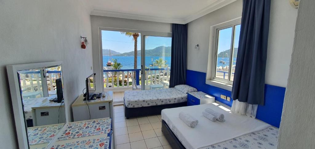a hotel room with two beds and a view of the ocean at Uysal Motel Beach in Marmaris