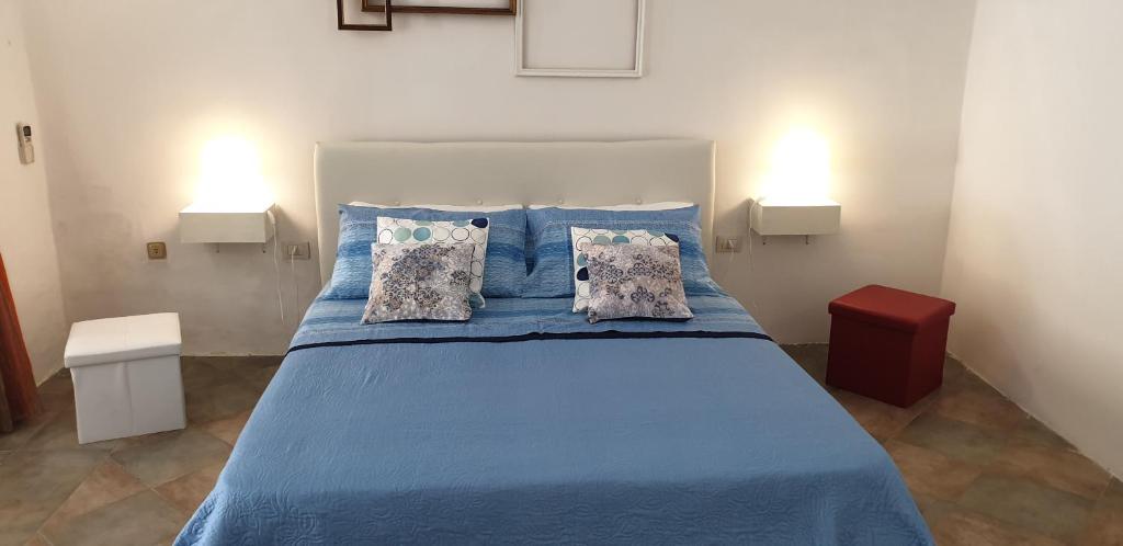 um quarto com uma cama azul com lençóis e almofadas azuis em Casa vacanze Ale&Va em Alezio