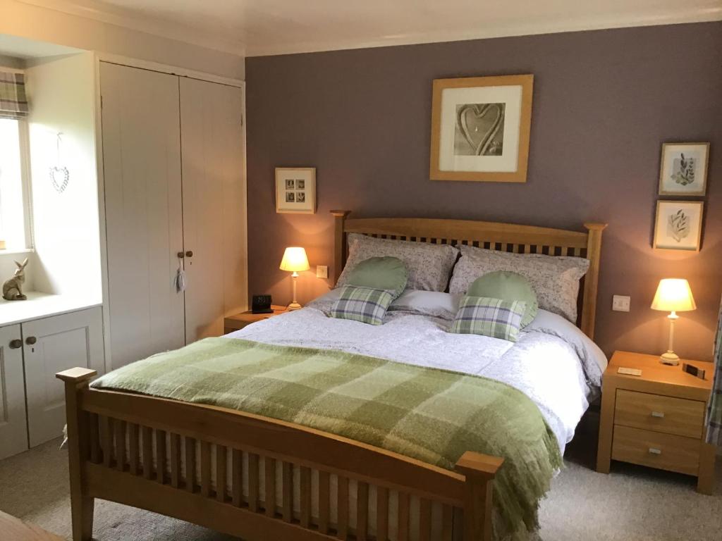 a bedroom with a bed with two night stands and two lamps at Yorecroft in Aysgarth