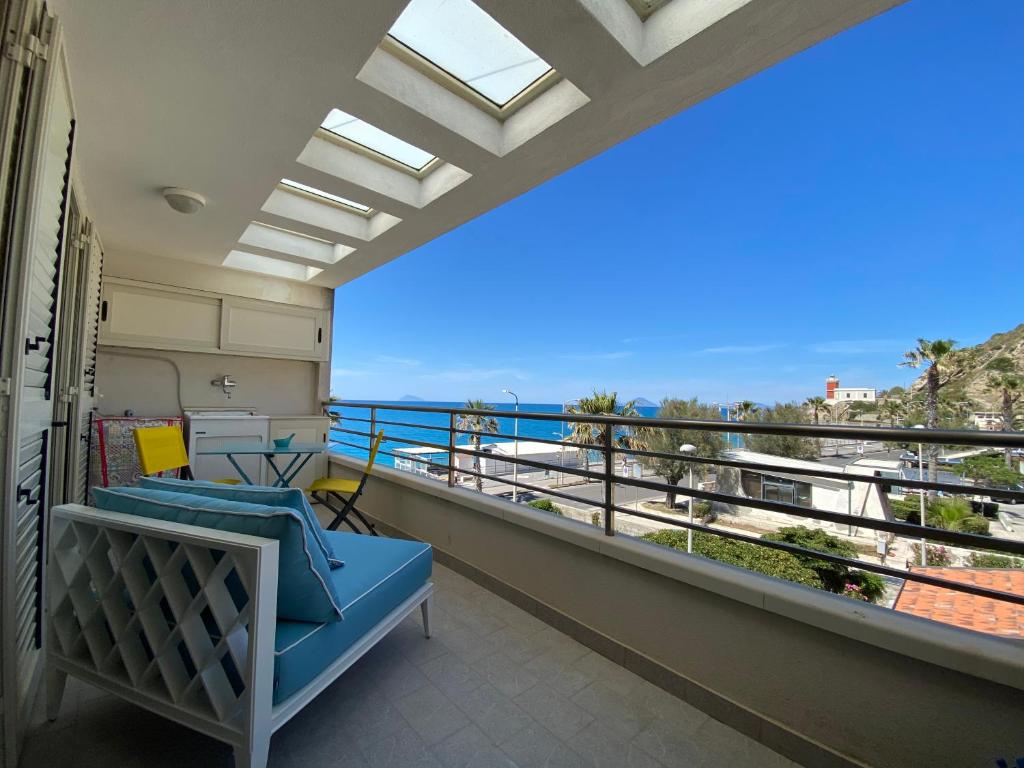 a balcony with a blue couch and a view of the ocean at Casa vacanze La Balena2 in Capo dʼOrlando