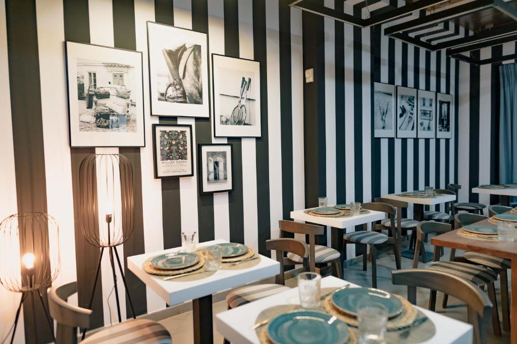 un restaurante con mesas, sillas y cuadros en la pared en The Little Corner B&B en Valencia