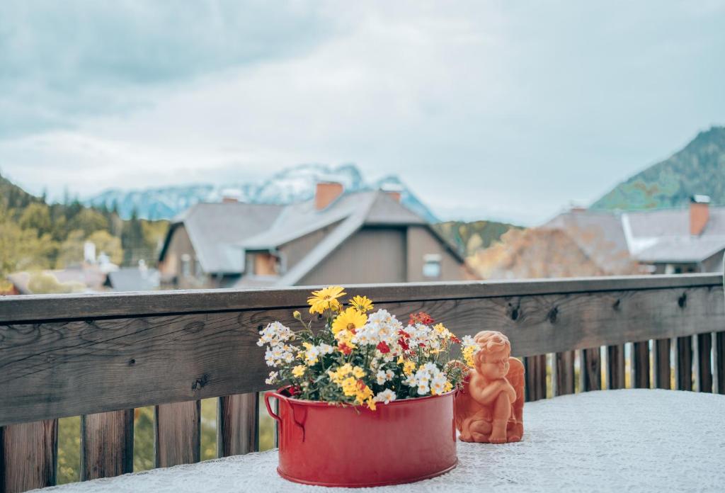 a pot of flowers sitting on a table with a figurine at Gästewohnung Sebastian in Grundlsee