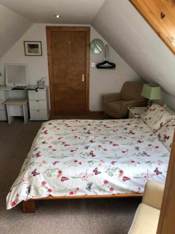 a bedroom with a bed with a floral bedspread at Rockvilla Guest House in Lerwick