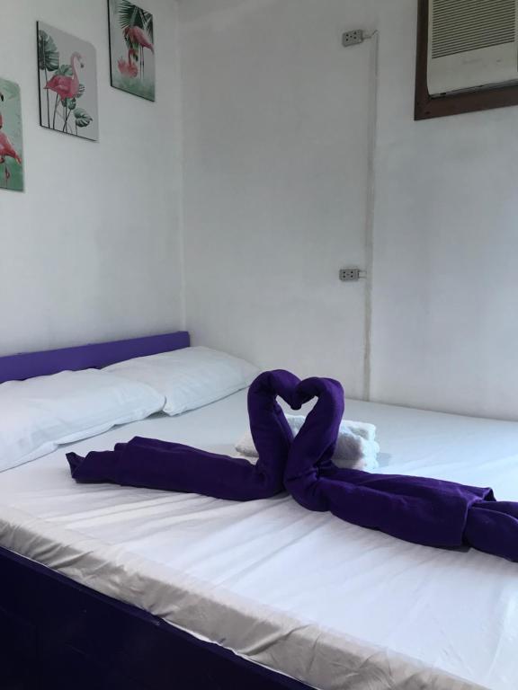 a purple ribbon laying on top of a bed at Bright and Cozy Space w/Netflix&Flamingo Design in Manila