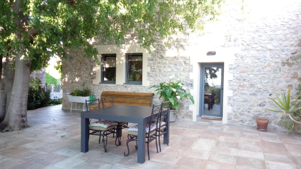 una mesa negra y sillas en un patio en La Casa dels Lledoners, en Masarach