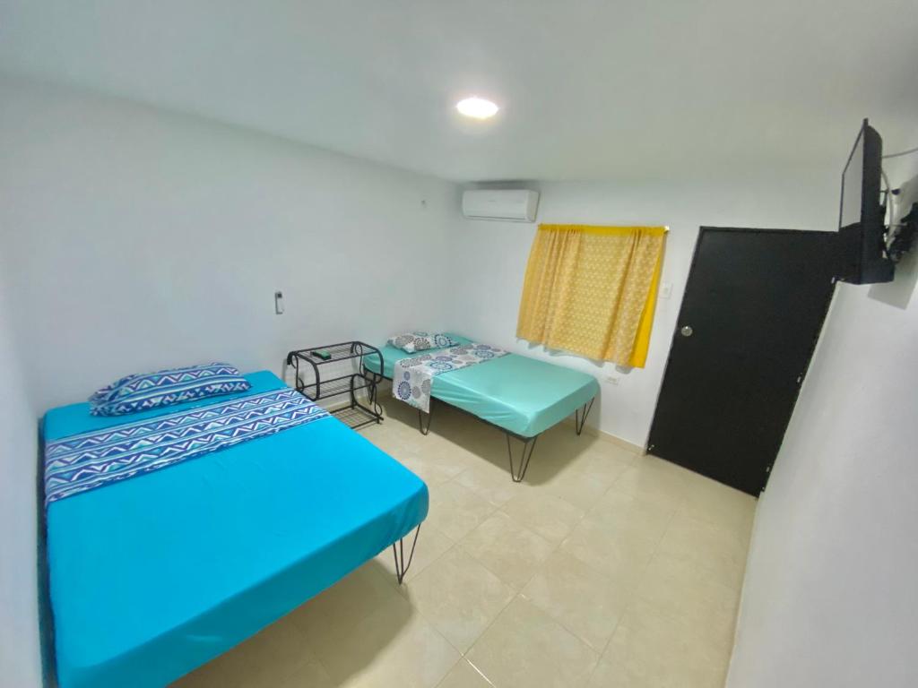 a room with two beds and a window at La Casona 42 in Barranquilla