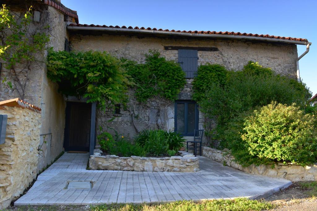 a stone house with a patio in front of it at Chez Pique-Fesse Chambre d'hote in Saint-Martin-lʼArs