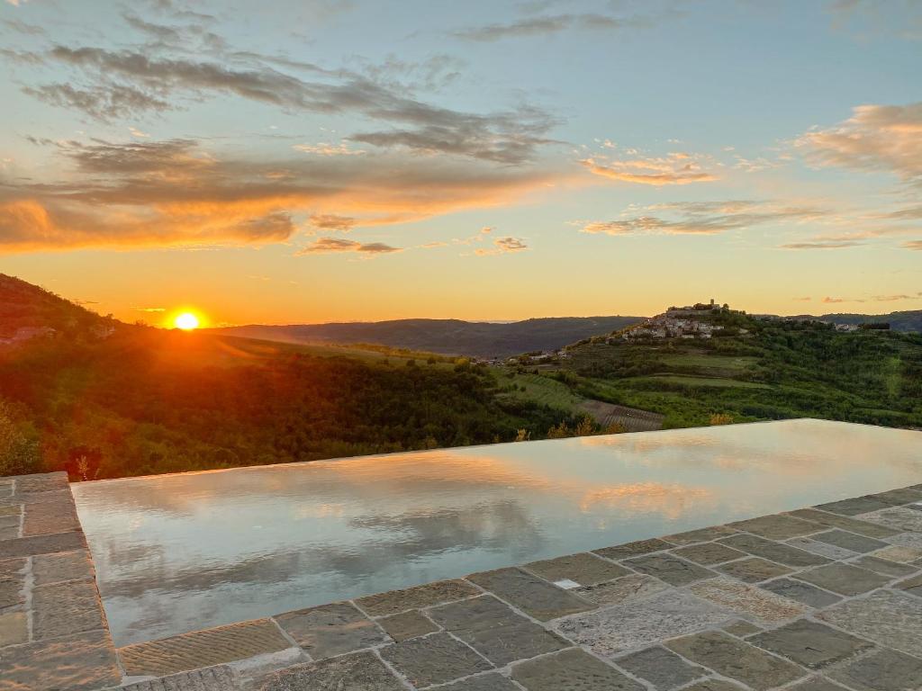 a swimming pool with the sunset in the background at Luxury estate with 6 hectares land near hilltop town Motovun in Kaldir