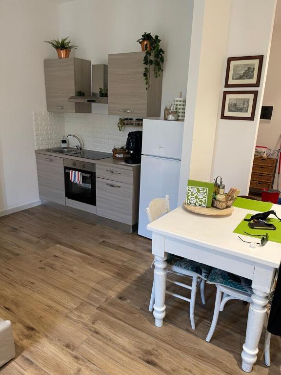 una cucina con tavolo bianco e frigorifero bianco di Green Appartamenti i Portici nel centro storico a Melzo