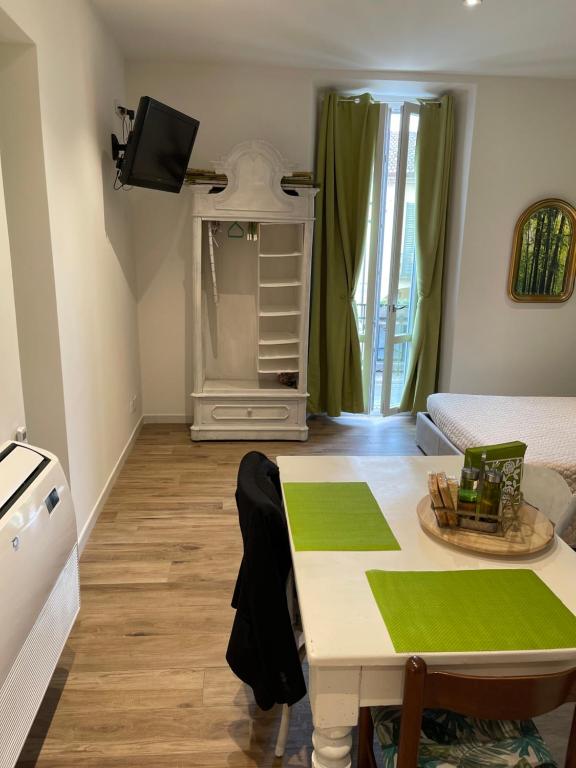 un soggiorno con tavolo e letto di Green Appartamenti i Portici nel centro storico a Melzo