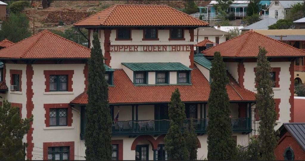 a building with red tile roofs and trees at Copper Queen Hotel in Bisbee