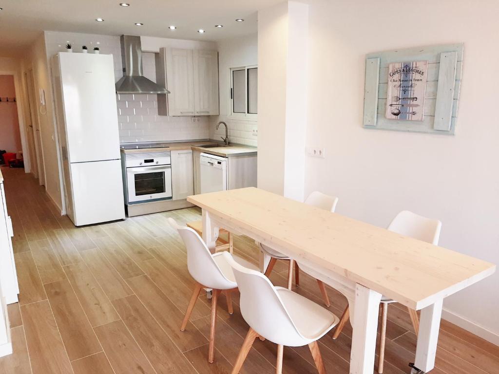 a kitchen with a wooden table and white appliances at Tarragonaapartments Prim Reus in Reus