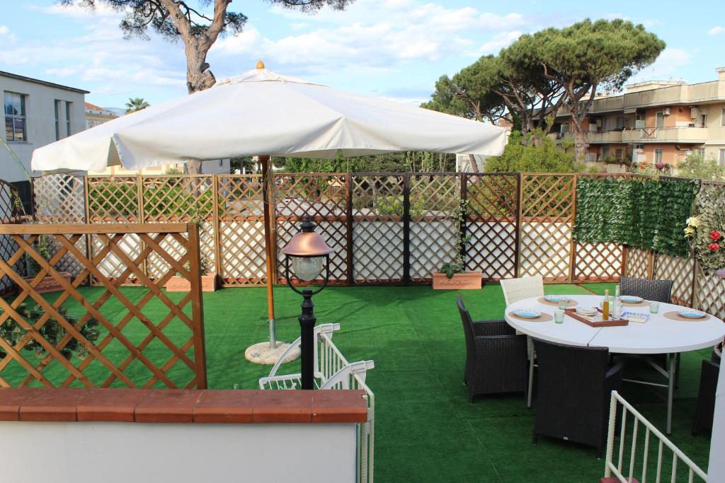 a patio with a white umbrella and a table and chairs at Todisco Apartament in Pompei