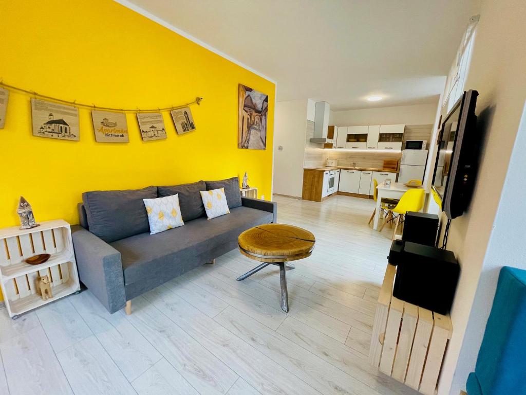 a living room with a couch and a yellow wall at Apartmán Kežmarok in Kežmarok