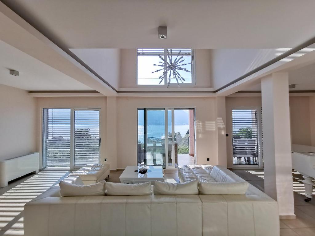 uma grande sala de estar com um grande sofá e janelas em Villa Dea em Kotor