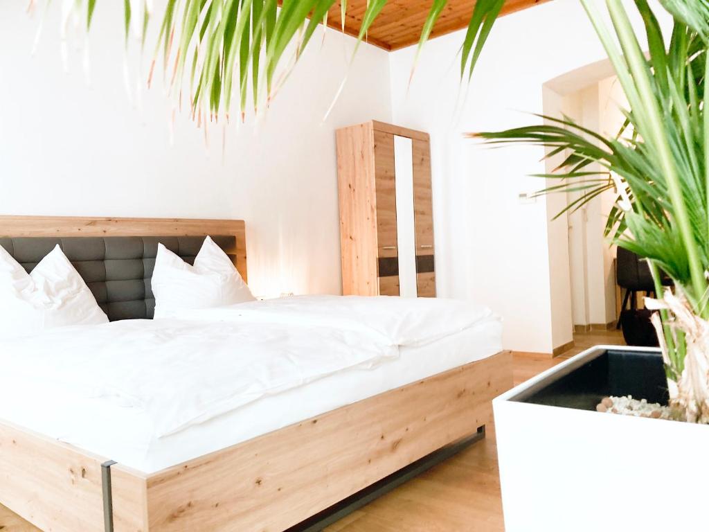 a bedroom with a wooden bed in a room with potted plants at APARTMENTS zum Wohlfühlen MARIAZELL in Mariazell