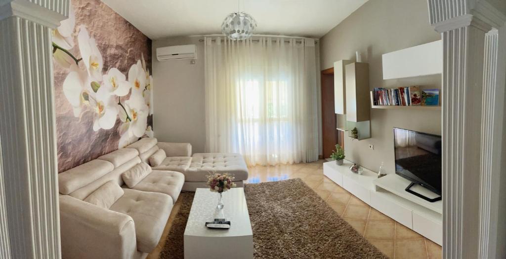 - un salon avec un canapé et une télévision dans l'établissement SunKissed Centre Apartment, à Vlorë