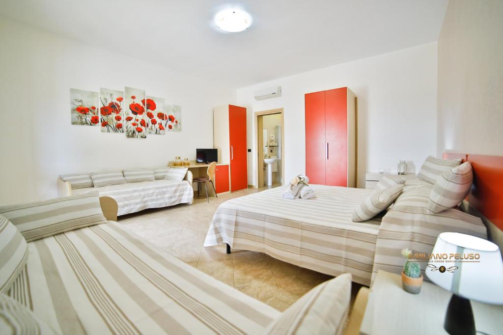 Habitación grande con 2 camas y sofá en B&B La Casa di Attilio, en Punta Prosciutto