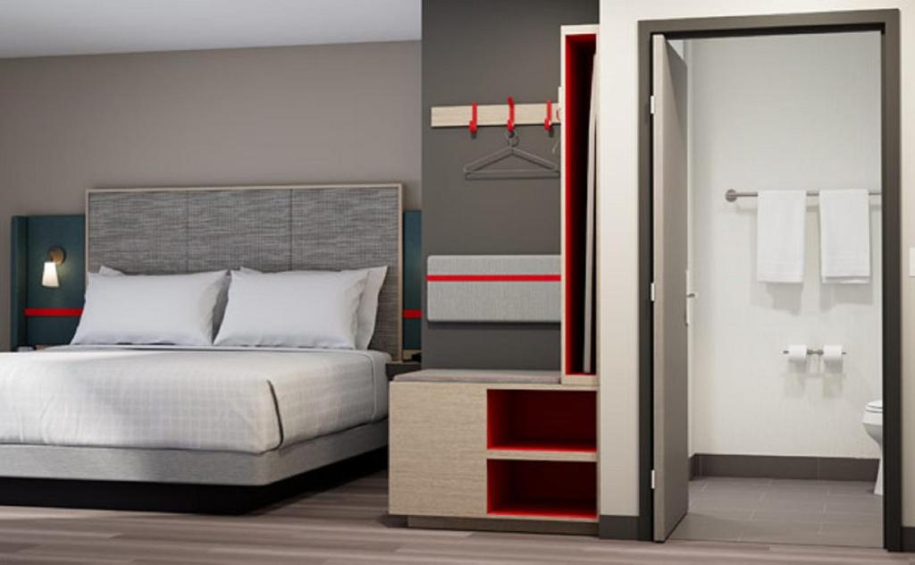 a bedroom with a bed and a bathroom at avid hotels - Zeeland by IHG in Holland
