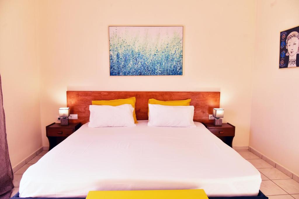 a bedroom with a large white bed with yellow pillows at Pension Irene in Sougia