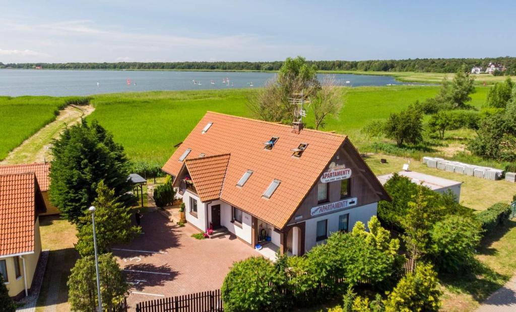 an aerial view of a house with a lake at Apartamenty Prima in Dziwnówek