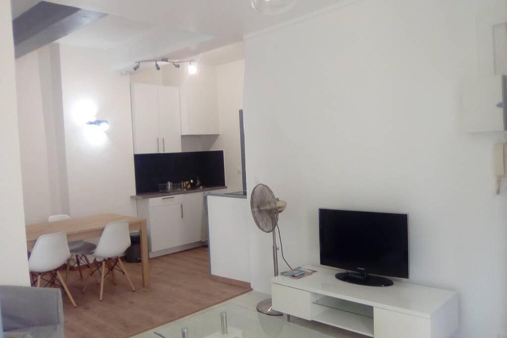 Il comprend un salon doté d'une télévision et d'une table avec des chaises. dans l'établissement Old Nice Center last stage, à Nice