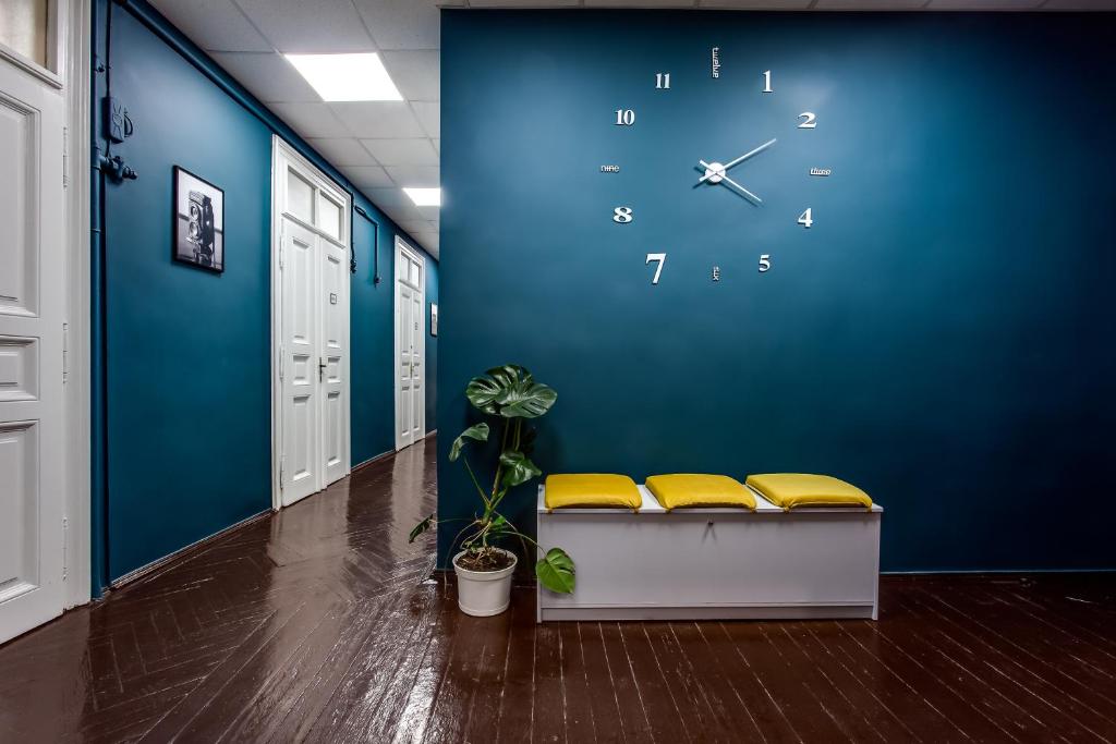 un reloj grande en una pared azul en un pasillo en Mister Hostel en Leópolis