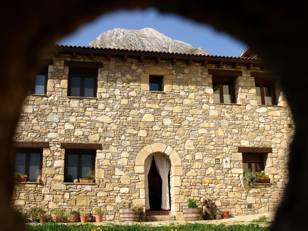 un gran edificio de piedra con una pared de roca en Casa Castel Turismo Rural, en Serrate