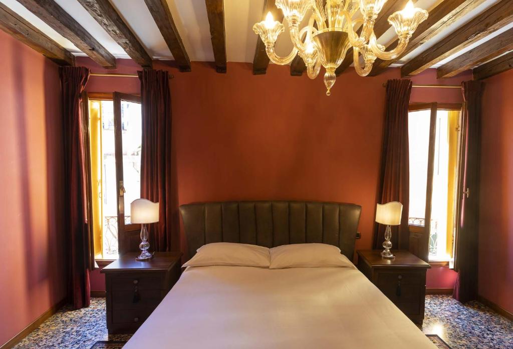 een slaapkamer met een groot bed en een kroonluchter bij Wow suite 5 min from San Marco in Venetië