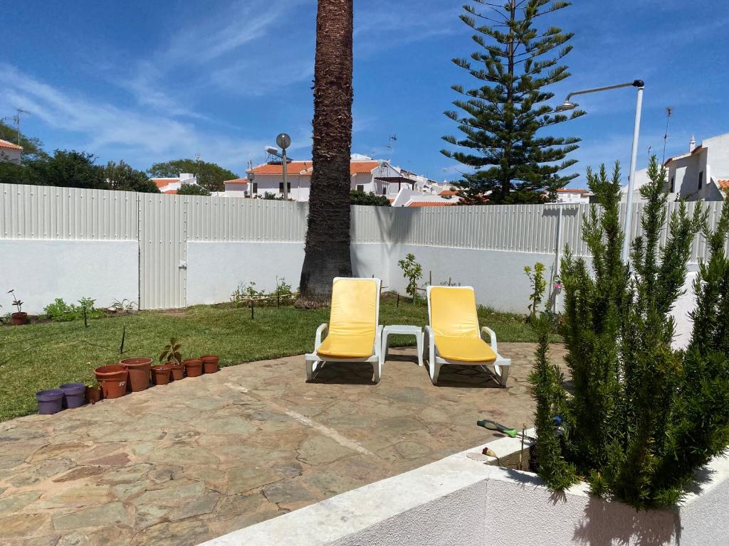 two yellow chairs sitting on a patio in a yard at Altura Inn Cottage in Altura