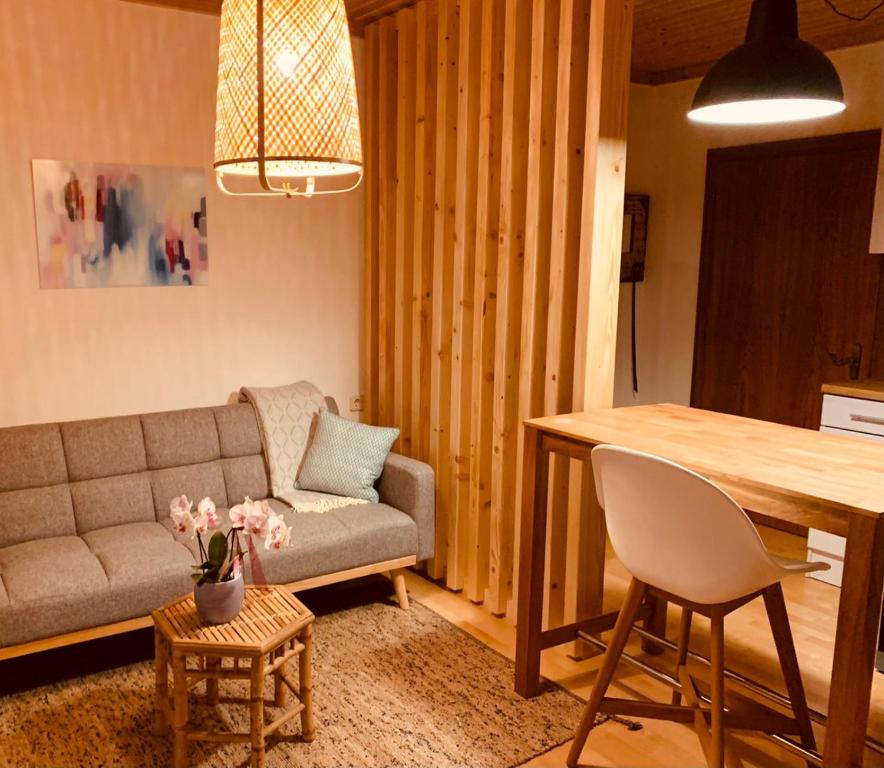 ein Wohnzimmer mit einem Sofa und einem Tisch in der Unterkunft Appartements Skruba in Steindorf am Ossiacher See