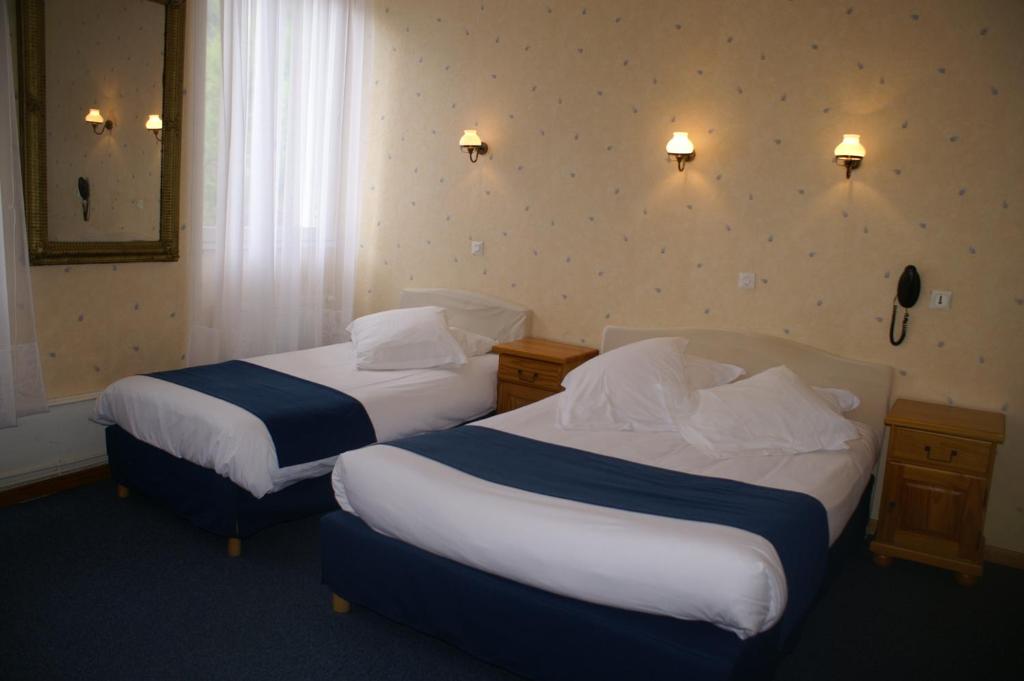 a hotel room with two beds in a room at Hôtel Céleste in Luchon