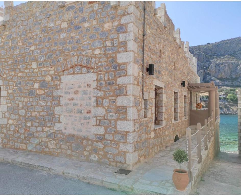 un edificio de piedra con una maceta delante de él en Perimenis Seaside House, en Yerolimin