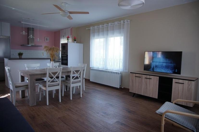 a kitchen and dining room with a table and a television at La Casa Del Rio in Granja Llumes