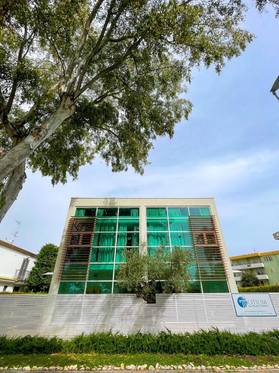 an office building with green windows and a tree at Otium casa vacanze-servizio spiaggia incluso a 250 mt-struttura pet friendly in Giulianova
