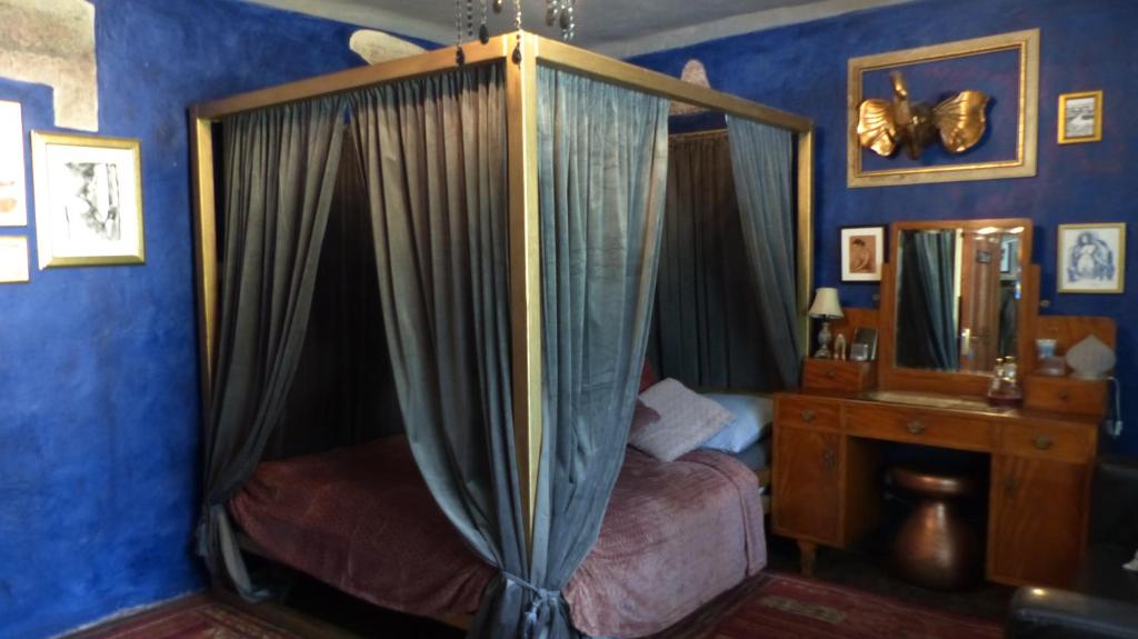 sypialnia z łóżkiem z baldachimem i lustrem w obiekcie Decadent Art Club w Czeskim Krumlovie