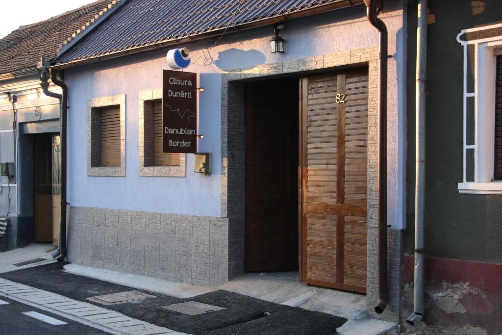 a building with a door and a sign on it at Clisura Dunarii - Danubian Border in Berzasca