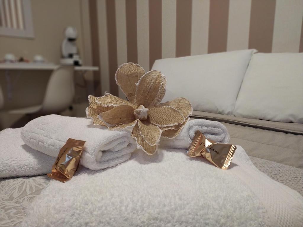 a pile of towels with a flower on top of a bed at Pensión Atenea Pilgrims in Caldas de Reis