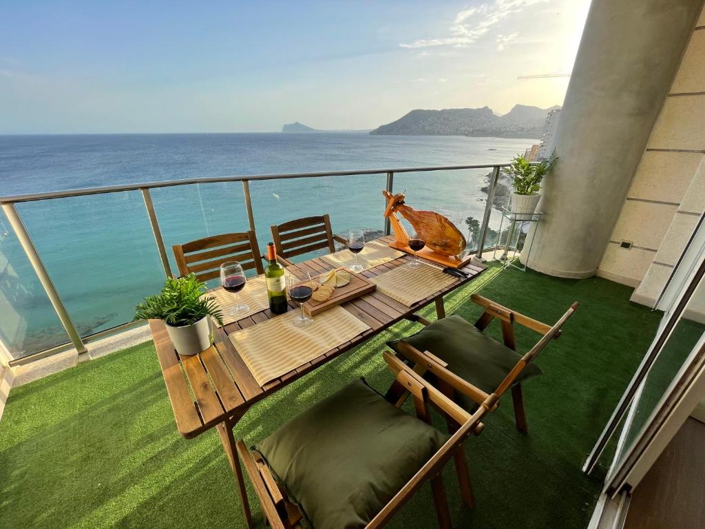 a balcony with a table and chairs and the ocean at CLP- Primera linea vistas piscina y parking in Calpe