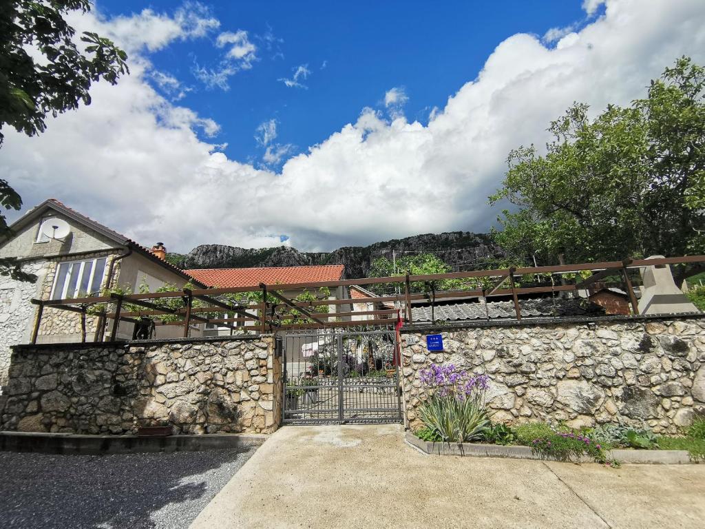 a stone fence in front of a house at Apartment Maja in Bribir