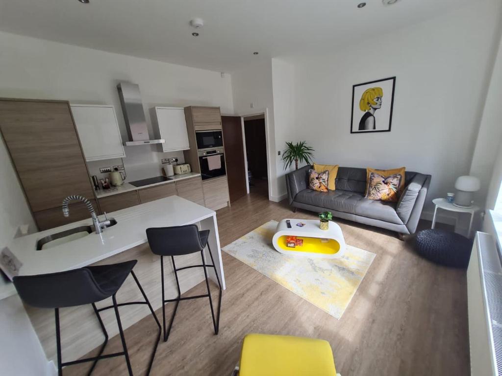 een keuken en een woonkamer met een bank en een tafel bij 34 Cuppin Street - luxury city centre apartment! in Chester